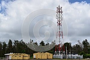 4G and 5G cell site with a supply station. Telecommunication tower with antennas.