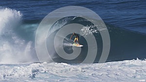 A 4K 60p clip of surfer grabbing the rail for a tube at pipeline on the north shore of oahu in hawaii