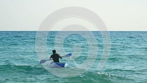 4K. active young sport man sitting in kayak boat and paddling over the sea , summer sports activity