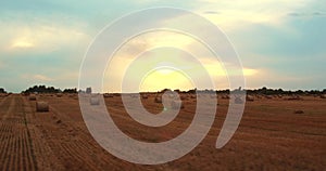 4k Aerial Field with Straw Bales Under Sunset Sky