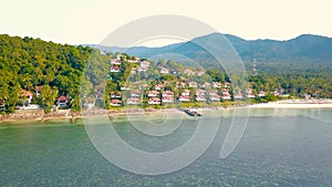 4K Aerial Front View of Surin Beach, Phuket. Beach, sea, sand and palms. Drone view of a beautiful white tropical sand beach on a