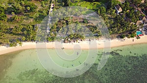 4K Aerial Front View of Surin Beach, Phuket. Beach, sea, sand and palms. Drone view of a beautiful white tropical sand beach on a