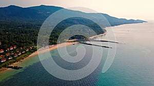 4K Aerial Front View of Surin Beach, Phuket. Beach, sea, sand and palms. Drone view of a beautiful white tropical sand beach on a