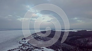 4k aerial video. Winter landscape on the village and river. Warm sunset light.