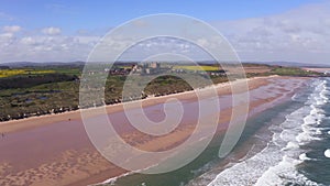 4K aerial view above Bamburgh beach and castle