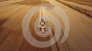 4K. Aerial view of agriculture process: tractor plows and makes seeding, sowing agricultural crops at field