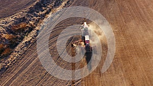 4K. Aerial view of agriculture process: tractor plows and makes seeding, sowing agricultural crops at field