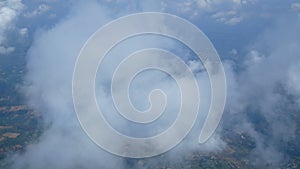 4K. aerial view through an airplane window. beautiful white clouds in blue sky background. traveling by air.