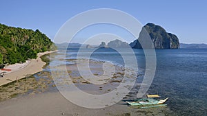 4k Aerial view of El Nido, Palawan, Philippines. Banca boat moored in shallow water during low tide. Tropical beach with