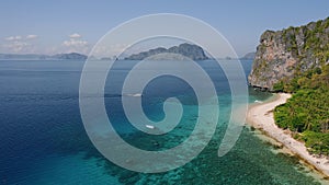 4K Aerial view of first tourists boats arriving the tropical beach of Dilumacad or Helicopter island. El Nido, Palawan