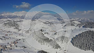 4K Aerial view of Fundata village from Rucar-Bran Pass in Romania during a winter morning at the bottom