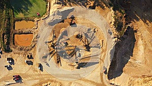 4K. Aerial view of a large sand quarry in working process with heavy machinery: sorting conveyor, bulldozers, excavators, trucks