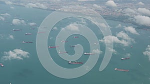 4K Aerial view of many container ships anchored at water area against port terminals
