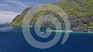 4K Aerial view of strait near Matinloc Island in El Nido, Palawan, Philippines. Toursit outrigger boat in blue water