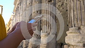 4K, Asian woman messaging on smartphone with columns Temple of Hadrian