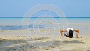 4K. athletic man workout by  push up at the sandy beach, part of his cross fitness workout.