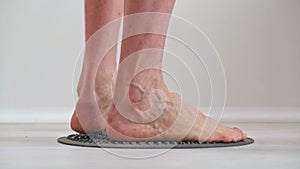 4K. Bare male feet trample on an orthopedic massage mat. Prevention of diseases.