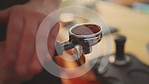 4k, barista tempering ground coffee into espresso pitcher, slow motion