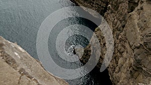 4K Beautiful view of Traelanipan, Legs Man Sitting Edge Cliff in Vagar, Faroe