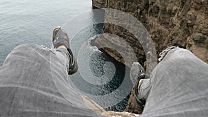 4K Beautiful view of Traelanipan, Legs Man Sitting Edge Cliff in Vagar, Faroe