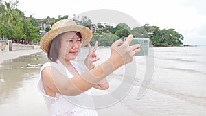 4k Beautiful young woman holding a smartphone. In order to take a picture of yourself from a camera phone Selfie. Tourism concep