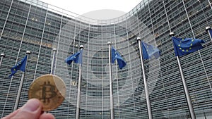 4K. Bitcoin in front of the European Union flags in a row waving in the wind in front of European Commission, Berlaymont