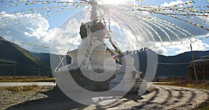 4k buddhist white stupa & flying prayer flags in shangrila yunnan, china.