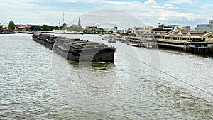 4K Cargo ship being towed by boats on the Chao Phraya River, Thailand