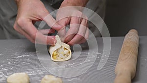 4K The chef puts the filling of potatoes and onion on the dough and make small pies
