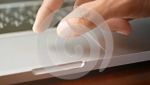 4K. close-up a man working with notebook laptop, using finger with keyboard and touchpad or trackpad for slide and zoom in, zoom