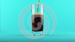 4K close-up shot of fizzy cola soda cold beverage drink pooring into glass blue background in studio
