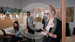 4k. closeup young beautiful blonde businesswoman uses a touchscreen tablet in the modern startup office.