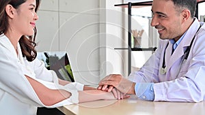 4K Doctor hold hand of asian woman patient help express empathy encourage tell diagnosis at medical visit