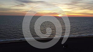 4k drone footage at sunrise over Maggi Hambling`s sculpture of the Scallop on the shingle beach in Aldeburgh