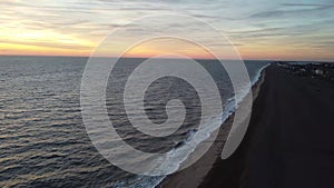 4k drone footage at sunrise over Maggi Hambling`s sculpture of the Scallop on the shingle beach in Aldeburgh