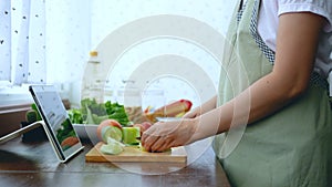 4K. female hand slicing fresh lettuce, prepare ingredients for cooking follow cooking online video clip on website via tablet.