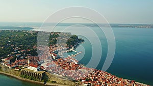 4K. Flight over old city Piran in the morning, aerial panoramic view with old houses, Tartini Square, St. George`s Parish Church.
