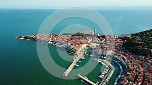 4K. Flight over old city Piran in the morning, aerial panoramic view with Tartini Square, St. George`s Parish Church and marina.