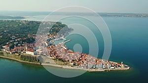 4K. Flight over old city Piran in the morning, aerial top panoramic view with old houses, Tartini Square, St. George`s Church.