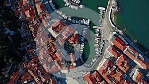 4K. Flight over old city Piran in the morning, aerial top view with Tartini Square, St. George`s Parish Church and marina.