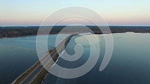 4K. Flight over road in the frozen lake in winter on sunset, aerial view