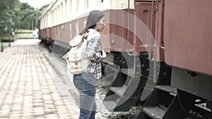 4K footage. happy Asian tourist woman at railway station, walk to the train and step up on stair. travel in Asia by vintage train.