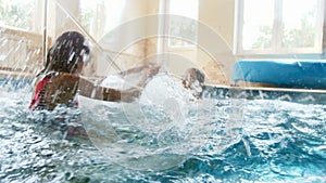 4k footage of two girls playing in swimming pool. Children splashing and having fight in water