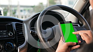 4K Hands of woman using using smartphone with green screen monitor at interior of SUV car for mobile application technology and tr