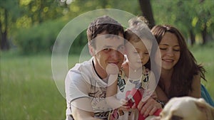 4K Happy young family are sitting in park. Portrait