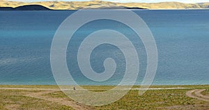 4k huge clouds rolling over lake namtso,Tibetans walking on the lakeside.