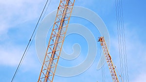 4K large construction site with several busy cranes at dusk with clear blue sky