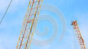 4K large construction site with several busy cranes at dusk with clear blue sky