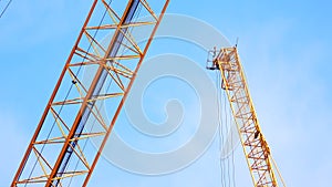 4K large construction site with several busy cranes at dusk with clear blue sky