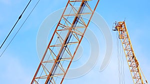 4K large construction site with several busy cranes at dusk with clear blue sky